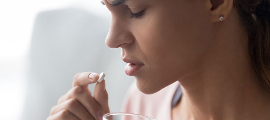 Erschöpfte Frau nimmt Pille ein