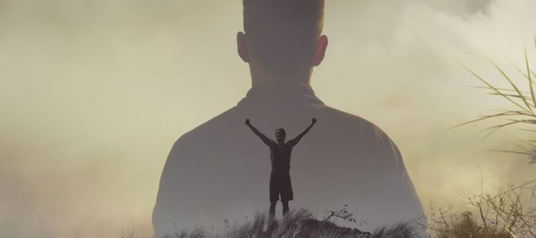 Mann reist arme brfreiend nach oben in der Silhooutte eines Körpers