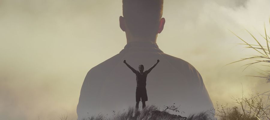 Mann reist arme brfreiend nach oben in der Silhooutte eines Körpers